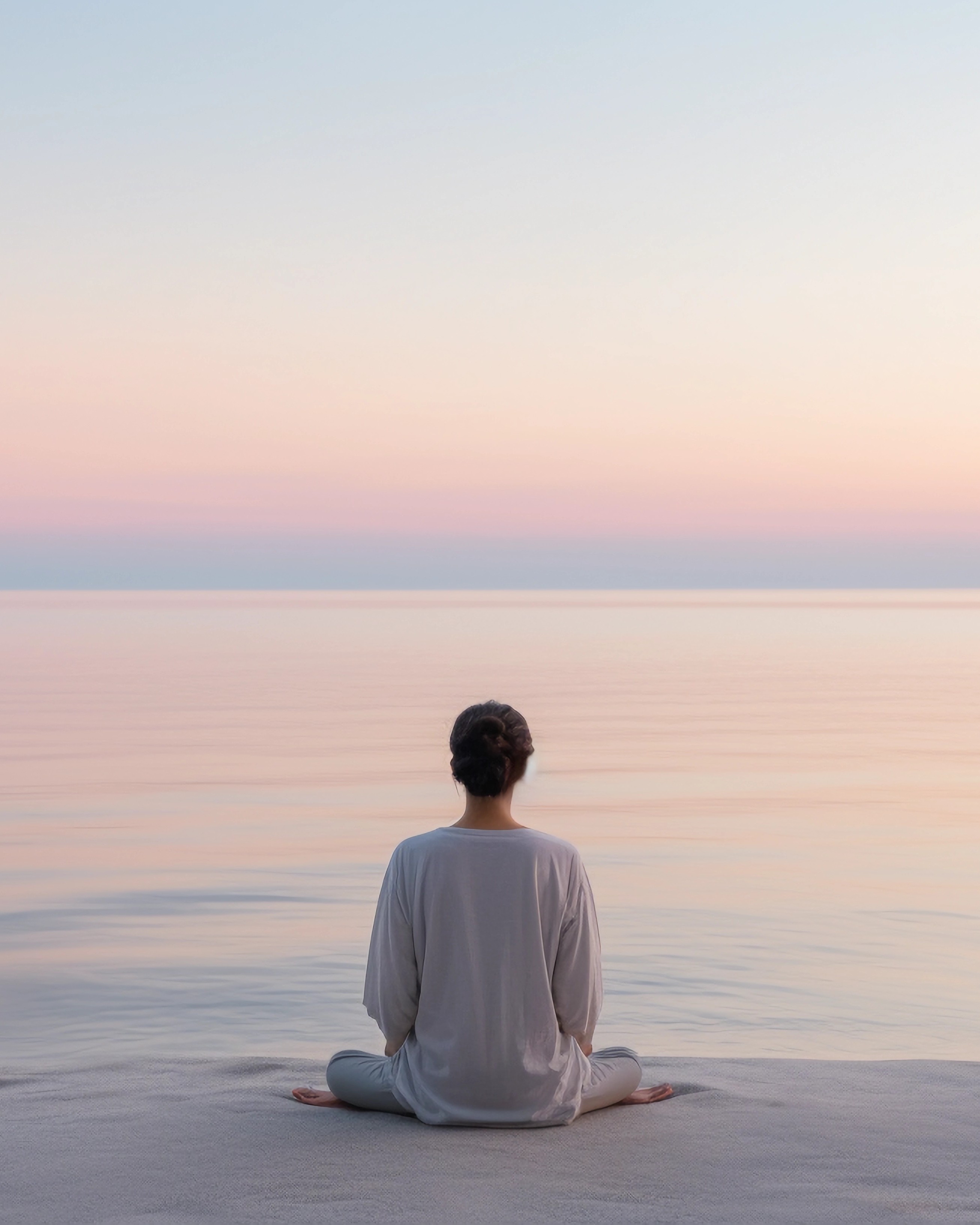 Woman in contemplative morning light at the ocean